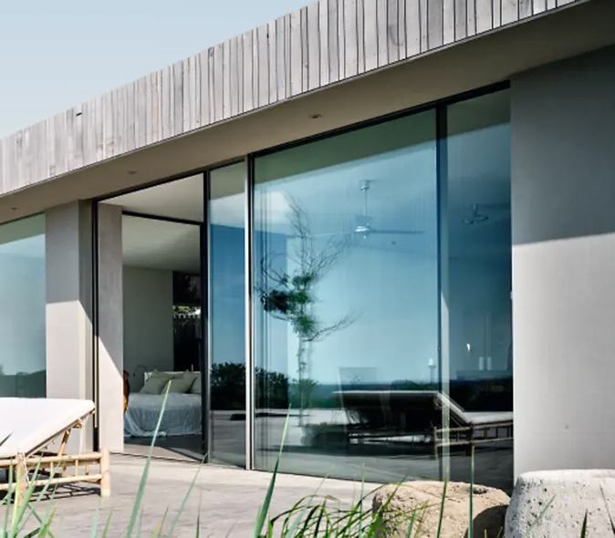 Porte d'entrée PVC blanche avec imposte et auvent en bois sur maison traditionnelle en Gironde