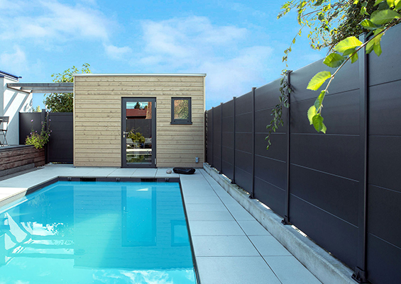Clôture alu gris anthracite pleine à lames horizontales autour d'une piscine extérieure, occultation totale pour intimité et sécurité, design moderne en région bordelaise.